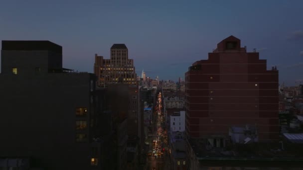 Vorwärts fliegen über die geschäftige Broadwaystraße zwischen Bürohochhäusern. Skyline mit beleuchteten Wolkenkratzern. Manhattan, New York City, USA — Stockvideo
