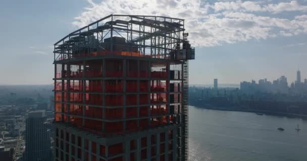 Aerial view of upper section of high rise building under construction against sky with bright clouds. New York City, USA — Stock Video