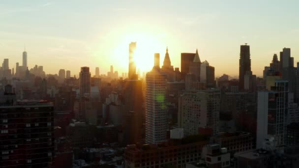Leć nad miasto. Sylwetki wysokich wież biurowych przeciwko zachodzącemu słońcu. Manhattan, Nowy Jork, USA — Wideo stockowe