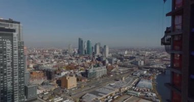 Büyük şehrin havadan panoramik görüntüsü. İnşaatta yüksek gökdelenlerin etrafında uçmak. Long Island Şehir Tren İstasyonu ve Newtown Creek boyunca gelişmeler. New York City, ABD