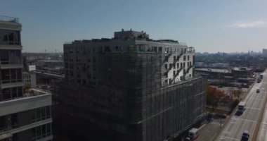 Çatı terasları ve iskeleleri olan bir apartmanın üzerinden uçun. Endüstriyel ya da lojistik alanın çok kanallı ekspres yolu ve panoramik görüntüsü ortaya çıkıyor. New York City, ABD