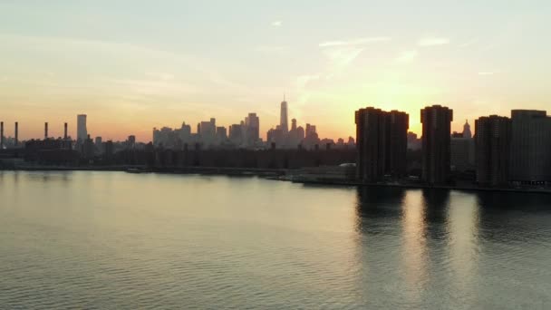 Filmagem aérea descendente de edifícios de apartamentos à beira-mar ao anoitecer. Skyline com arranha-céus da baixa à distância. Manhattan, Nova Iorque, EUA — Vídeo de Stock