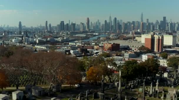Forwards fly above historic Calvary Cemetery and surrounding town borough. Modern high rise buildings in background. New York City, USA — 图库视频影像