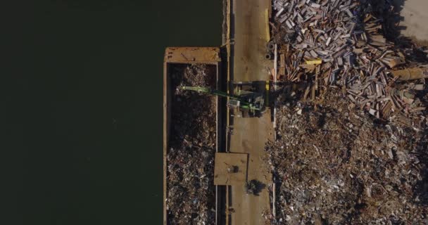 Aerial birds eye overhead top down descending view of loading metal scrap on barge. Recycle and ecology concept. New York City, USA — стоковое видео