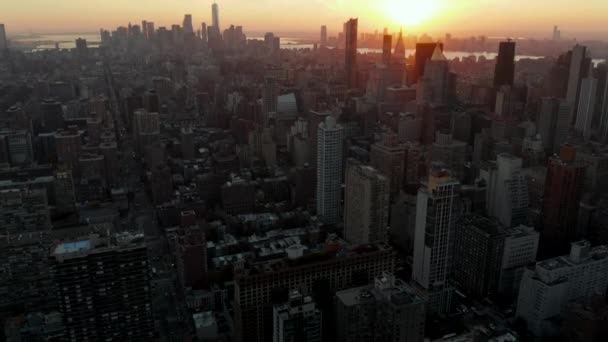 En arrière voler au-dessus de la ville. Vue aérienne du paysage urbain contre le coucher du soleil doré. Manhattan, New York, États-Unis — Video