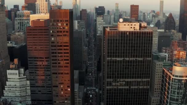 Larga avenida recta ancha rodeada de oficinas de gran altura o edificios de apartamentos. Vista aérea del centro de la ciudad al atardecer. Manhattan, Nueva York, Estados Unidos — Vídeo de stock