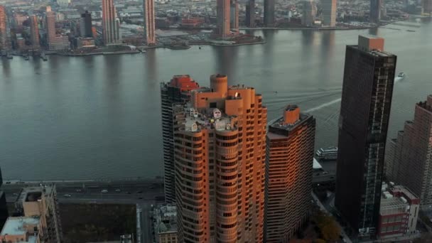 Vlieg rond een groep hoogbouw appartementenhuizen aan de East River waterkant. Luchtfoto van de stad bij zonsondergang. Manhattan, New York City, Verenigde Staten — Stockvideo