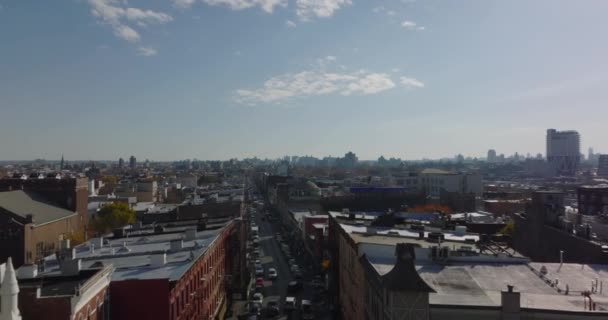 Backwards fly above street in urban borough. Revealing tall tower of catholic church. Brooklyn, New York City, USA — 图库视频影像