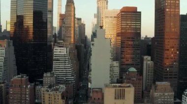 Gün batımında şehirdeki yüksek ofis binalarının kayışı. Şehir merkezinden geçen uzun düz bir sokak. Manhattan, New York City, ABD