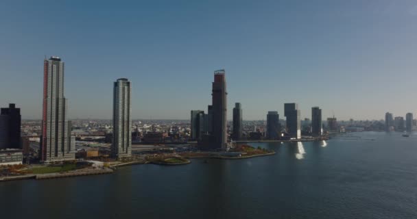 海滨的一排高耸的现代化公寓楼.在东河上空飞行晴朗的天空。New York City, USA — 图库视频影像