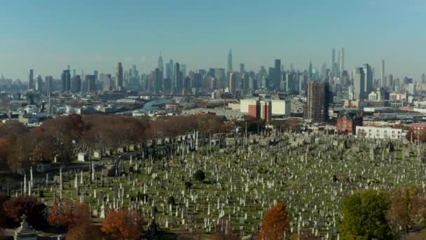 Forwards fly above historic Calvary Cemetery with tall modern high rise buildings in background. Queens, New York City, USA — Vídeo de Stock