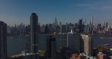 İleri daireler, yüksek binaların etrafında uçar. Nehir manzarası ve şehir merkezindeki yüksek gökdelenler gözler önüne seriliyor. Manhattan, New York City, ABD