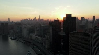 Rıhtımdaki binaların havadan görüntüsü. Şehir merkezindeki gökdelenler. Gün batımına karşı atış. Manhattan, New York City, ABD