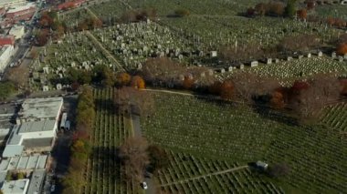 Calvary Mezarlığı 'ndaki mezar taşlarının yüksek açılı görüntüsü. Büyük ve tarihi bir defin yeri. Arka planda yoğun ekspres yol. Queens, New York City, ABD