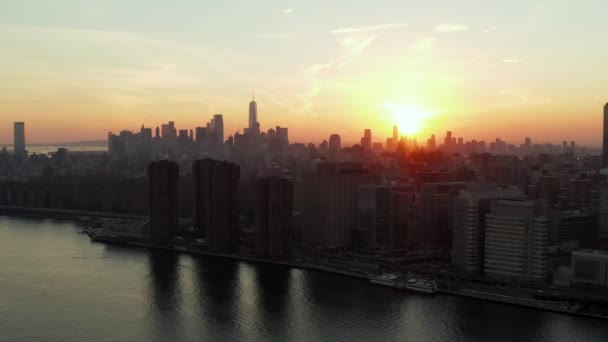 Fly along waterfront. Romantic colourful sunset above large city. Silhouettes of downtown skyscrapers. Manhattan, New York City, USA — Stock Video