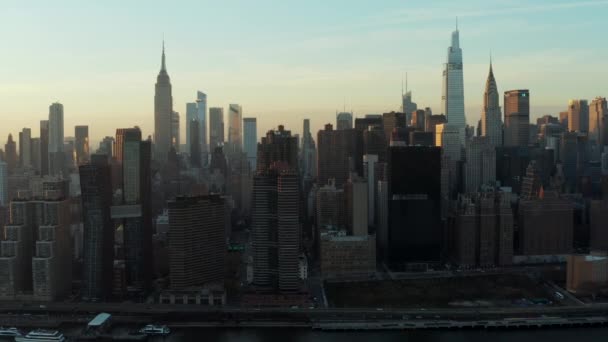 Slider av vattnet och höga byggnader i centrum stadsdelen i skymningen. Ikoniska Empire State Building, Chrysler och One Vanderbilt torn. Manhattan, New York City, USA — Stockvideo