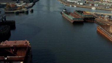Newtown Creek 'te yük mavnası. Yelkenliler bankaya demirledi. Modern şehir merkezindeki gökdelenleri göster. New York City, ABD