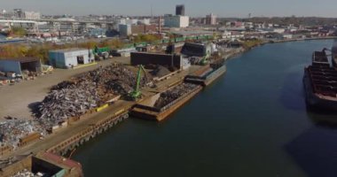 Kargo teknesine metal parçaları yükleyen makinelerin hava görüntüsü. Şehirdeki sanayi bölgesi. Geri dönüşüm ve ekoloji kavramı. New York City, ABD