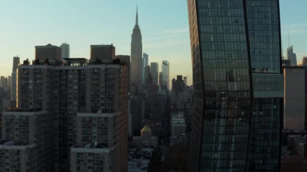 Adelante vuelan entre edificios de apartamentos de gran altura. Vista reveladora de la torre de oficinas y el icónico Empire State Building. Manhattan, Nueva York, Estados Unidos — Vídeo de stock