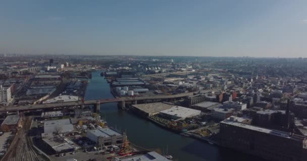 Letecký panoramatický výhled na rozvoj města podél Newtown Creek. Průmyslové a logistické lokality na nábřeží. New York City, USA — Stock video