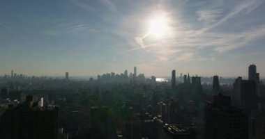 Büyük şehrin havadan panoramik görüntüsü. Şehir merkezindeki gökdelenlerin siluetleri güneşe karşı. Manhattan, New York City, ABD