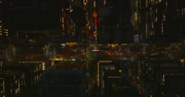 Aerial birds eye overhead top down view of cars waiting at crossroads in night city. Tall buildings around roads. Manhattan, New York City, USA — Stockvideo