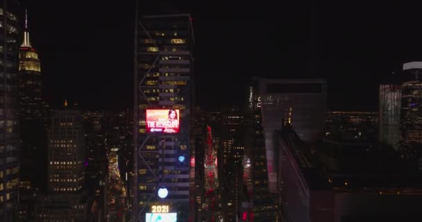Descending shot of high rise buildings with advertising displays. Digital billboards and busy streets around Times Square at night. Manhattan, New York City, USA — Vídeo de Stock