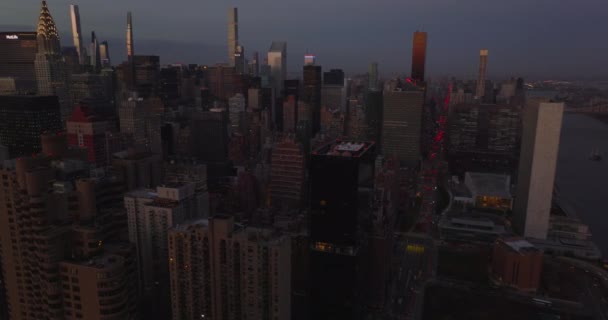 Imágenes aéreas nocturnas de apartamentos de gran altura o edificios de oficinas en la ciudad. Rascacielos al anochecer. Manhattan, Nueva York, Estados Unidos — Vídeos de Stock