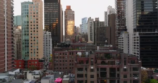 Voorwaarts vliegen tussen hoge flatgebouwen in de stad. Verschillende kleuren gevels. Manhattan, New York City, Verenigde Staten — Stockvideo