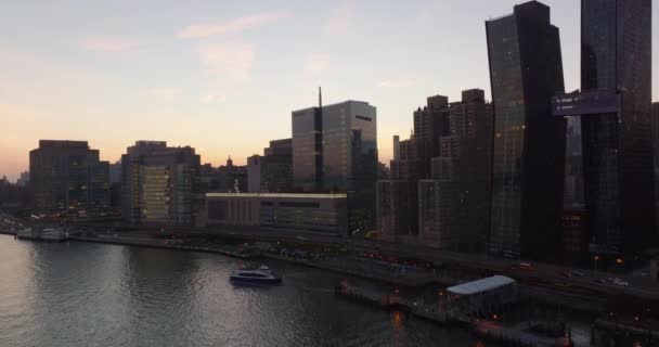 Stijgende beelden van moderne hoogbouw en drukke meerbaans weg aan de waterkant. Uitzicht tegen de kleurrijke zonsondergang hemel. Manhattan, New York City, Verenigde Staten — Stockvideo