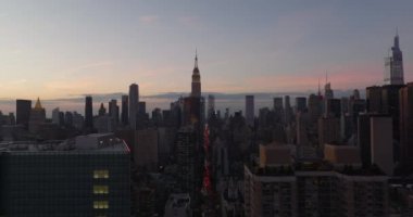Şehir merkezindeki yüksek binaların panoramik manzarası. Empire State Binası 'nın tepesinde alacakaranlıkta gökyüzüne karşı aydınlandı. Manhattan, New York City, ABD