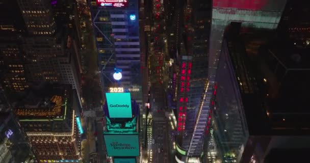 Nakloňte záběr budov kolem Times Square. Lesklé fasády odrážející barevné záblesky a zářící z velkých displejů. Manhattan, New York City, USA — Stock video
