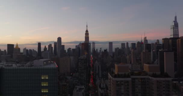 Panoramic view of high rise buildings in midtown. Illuminated top of Empire State Building against sky at dusk. Manhattan, New York City, USA — Stock Video