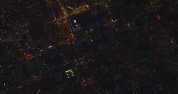 Mata burung udara di atas kepala panning bawah panning melihat jalan yang sibuk di kota malam hari. Kontur beriluminasi gedung pencakar langit modern. Manhattan, New York City, Amerika Serikat — Stok Video