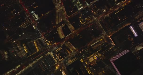 空中の鳥の目は、夜の街の通りで重いトラフィックの下のビューの上にオーバーヘッド。通りの通常のグリッドでバラの上を飛ぶ。米国ニューヨーク市マンハッタン — ストック動画