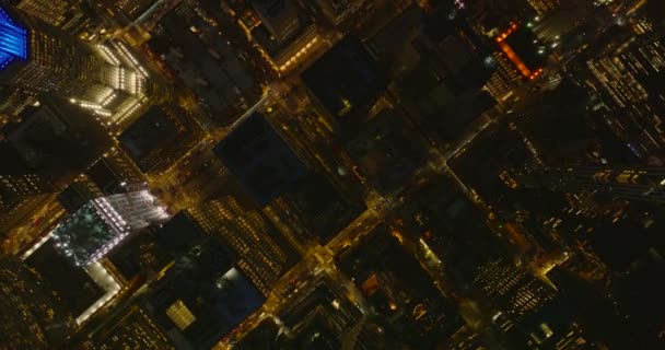 Aerial birds eye overhead top down view of illuminated streets and high rise apartment buildings in night city. Manhattan, New York City, USA — Stock Video