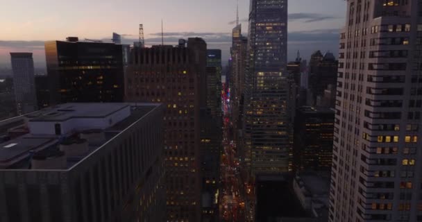 Forwards fly high above busy street between modern high rise downtown buildings. City at dusk. Manhattan, New York City, USA — Video Stock