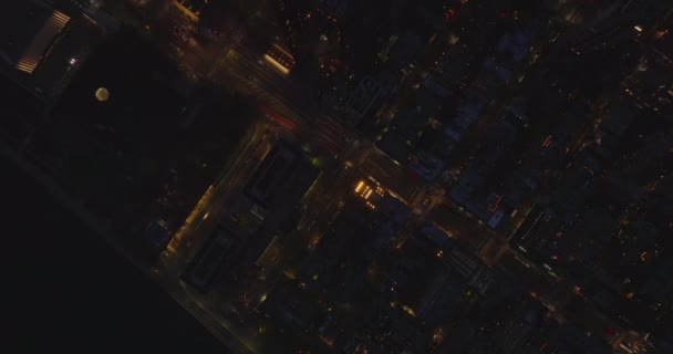 Aerial birds eye overhead top down panning view of night city. Cars driving in streets between high rise buildings. Manhattan, New York City, USA — 图库视频影像