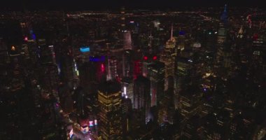 Aydınlatılmış gökdelenleri olan gece şehrinin havadan panoramik görüntüsü. Akşam kasabasının renkli ışıkları. Manhattan, New York City, ABD