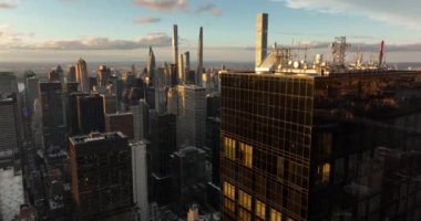 Parlak yüzlü, batan güneşi yansıtan modern gökdelenlerin etrafında uç. Yüksek ofis kuleleri olan şehir manzarası. Manhattan, New York City, ABD