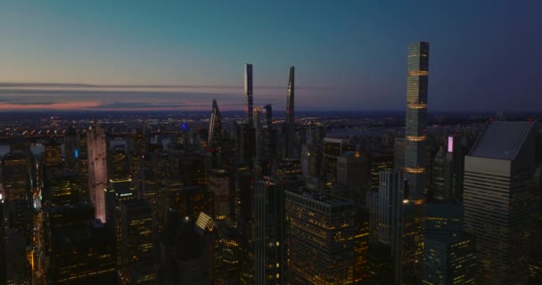 Az este fénypontja a belvárosban. Modern toronyházak megvilágított ablakokkal és színes égbolttal naplemente után. Manhattan, New York City, Amerikai Egyesült Államok — Stock videók
