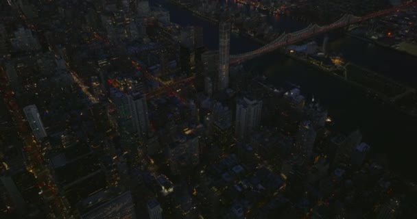 Vista de alto ângulo da Ponte Queensboro sobre o East River. Incline-se revelar cidade à noite. Tráfego intenso nas estradas. Manhattan, Nova Iorque, EUA — Vídeo de Stock