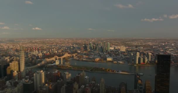 Aerial descending footage of Queensboro Bridge and buildings in Queens borough in sunset time. Manhattan, New York City, USA — Stock Video