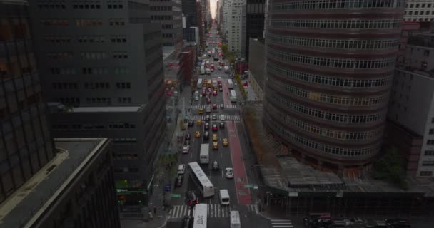 Forwards fly above busy avenue. Wide one way road sandwiched between modern high rise buildings. Manhattan, New York City, USA — Stock Video