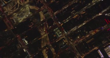 Gökyüzü kuşları tepeden aşağı gece kentinde çok yönlü ve çok katlı kavşağı görüyor. Caddelerde yoğun trafik var. Manhattan, New York City, ABD