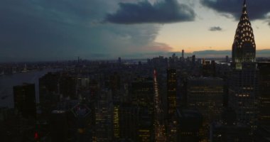 Alacakaranlıktaki şehir manzarasının hava panoramik görüntüsü. Gün batımından sonra şehrin üzerinde uç. Yüksek binalar ve şehir merkezindeki gökdelenler. Manhattan, New York City, ABD