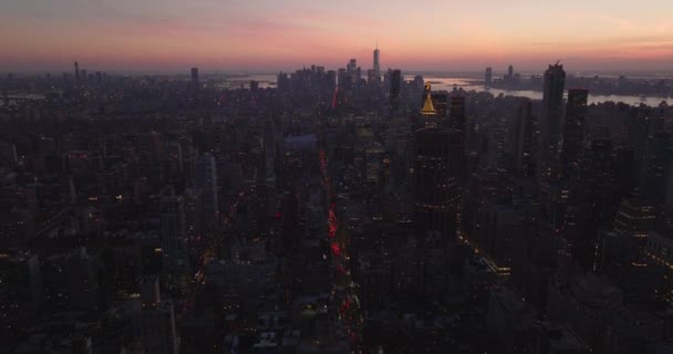 Aerial view of city development at dusk. Tilt up reveal cityscape against colourful twilight sky. Manhattan, New York City, USA — стокове відео