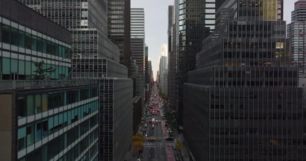 Fly above wide long and straight avenue in downtown. Modern tall skyscrapers standing around. Manhattan, New York City, USA — Vídeo de Stock