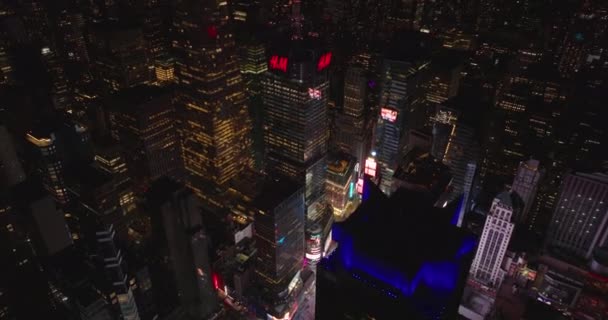 Vuela por encima de la ciudad nocturna. Inclinarse hacia abajo en coloridas pantallas de publicidad intermitente en Times Square. Manhattan, Nueva York, Estados Unidos — Vídeo de stock