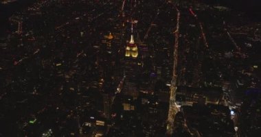 Empire State Binası. Üst kısmı aydınlanmış ve kule şeklinde. Gece şehir manzarasını gözler önüne serin. Manhattan, New York City, ABD